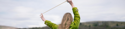 Sarah standing with her back to the camera, holding a cello bow in her hand