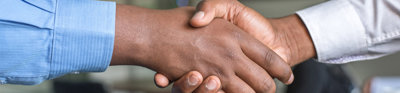 Two people shaking hands with only the hands in view. 
