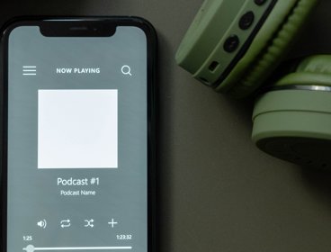 Smartphone playing a podcast with headphones
