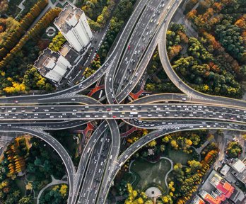 An aerial view of a busy interchange highway in a big city.