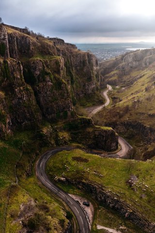 A view over Cheddar Gorge, with rocky valley sides and a winding road