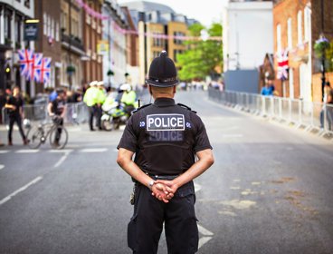 A policeman with his back to camera on a city street