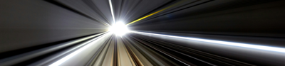 Blurred lines and central bright light depict high speed movment through a train tunnel.