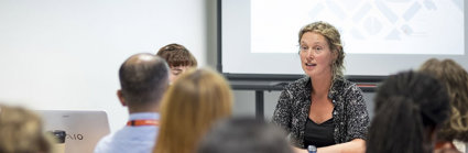 Discussion session at a conference, showing presenters and audience.