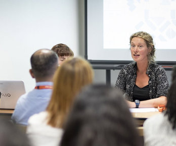 Discussion session at a conference, showing presenters and audience.