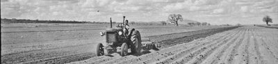 An old impage of a tractor ploughing a field