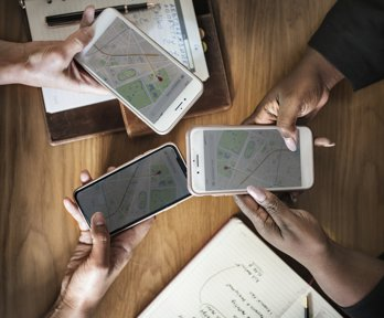 A group of people use maps on their phones