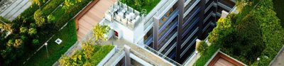 Tall building with green plants on the roof.