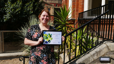 Rachel Owen holding the Geographical Association Publisher award for her resources, on the steps of the Society
