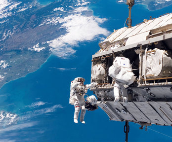 Two astronauts on a space walk from space shuttle.