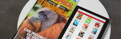 A pile of three print copies of Geographical magazine next to a tablet that displays covers of magazines in the Geographical magazine app.