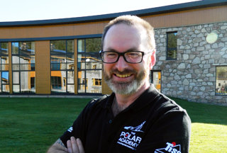 Headshot of Craig Mathieson. He is standing outside a building on a sunny day while wearing a Polar Academy polo.