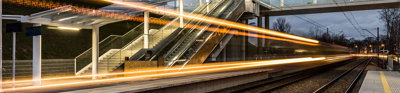 Long exposure photograph of train lights at a train station.