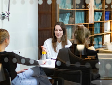 Three people sat in the Members' Room at the Society. They are chatting.