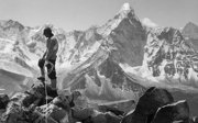 Black and white photograph of an explorer overlooking the Mount Everest mountain range.