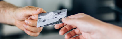 Close up of a Society membership card being passed from one person's hand to another's.