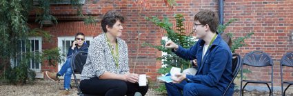 Two conference delegates seated and having a conversation