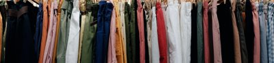 A clothing rail containing trousers and shorts of different colours