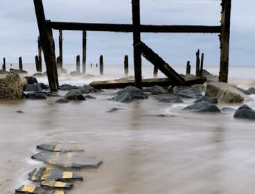 Titled 'end of the road', shows a broken pieces of road going into the sea