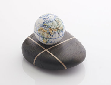 Porcelain globe on top of a dark bog oak.