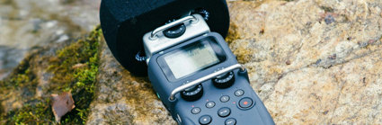 Hand-held microphone layingon a rock in a river.