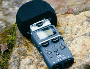 Hand-held microphone layingon a rock in a river.