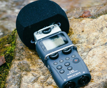 Hand-held microphone layingon a rock in a river.