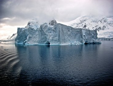 White iceberg near white mountains in Antarctica