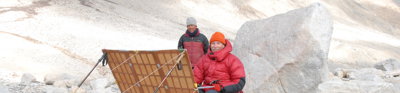 Tony Foster painting Mount Everest. A person next to Tony is looking at the painting.