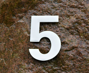 A white number 5 on a brown rock background