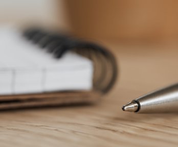 Open notebook and ballpoint pen on a table. 