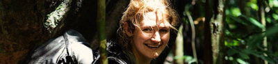 Explorer Lucy Shepherd in rainforest with filming equipment.