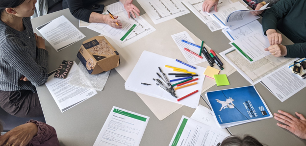 Researchers working together at a table, brainstorming and writing notes 