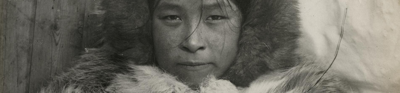 Arnarulunnguaq, an indiegnous Greenlandic woman accompanied Knud Rasmussen from Greenland to Alaska. Arnarulunnguaq staresforard with a nutural expression wearing a fur top and fur hood. The image is devoid of colour.