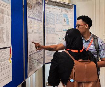 A presenter discussing their poster with another conference attendee.