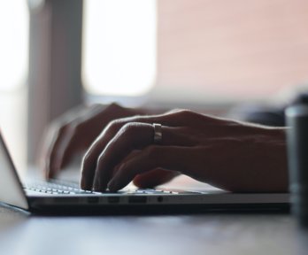 Person typing on a laptop keyboard.