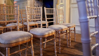 Rows of empty wooden chairs setup for a wedding ceremony.