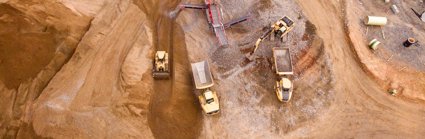 Aerial photography of dumper trucks and other industrial vehicles located in a mining area