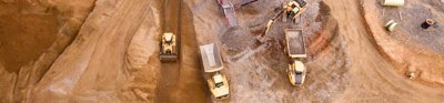 Aerial photography of dumper trucks and other industrial vehicles located in a mining area