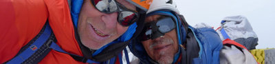 Mick Fowler and Victor Saunders on the summit of snowy Yawash Sar in mountaineering gear. 