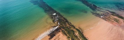 A beach and rocks from above