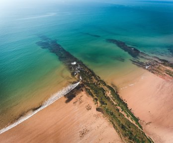 A beach and rocks from above