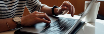 Person seated at the table using laptop.