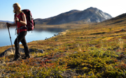 Person hiking next to mountain lake. 