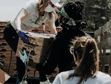 People passing boxes of food to each other.