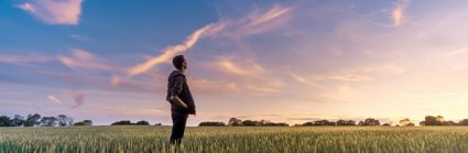 Man on grass field looking at the sky