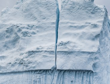 A large iceberg with a crack running down the middle of it