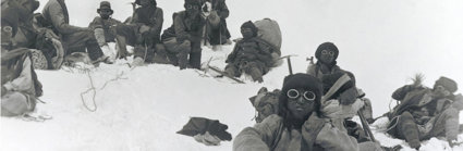 Historic black and white photograph of Sherpa climbers with mountaineering equipment on Mount Everest.