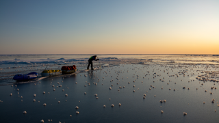 Børge Ouslan walking on ice at sunset.