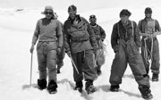 Group of five people in explorering gear posing for a photo in the snow.